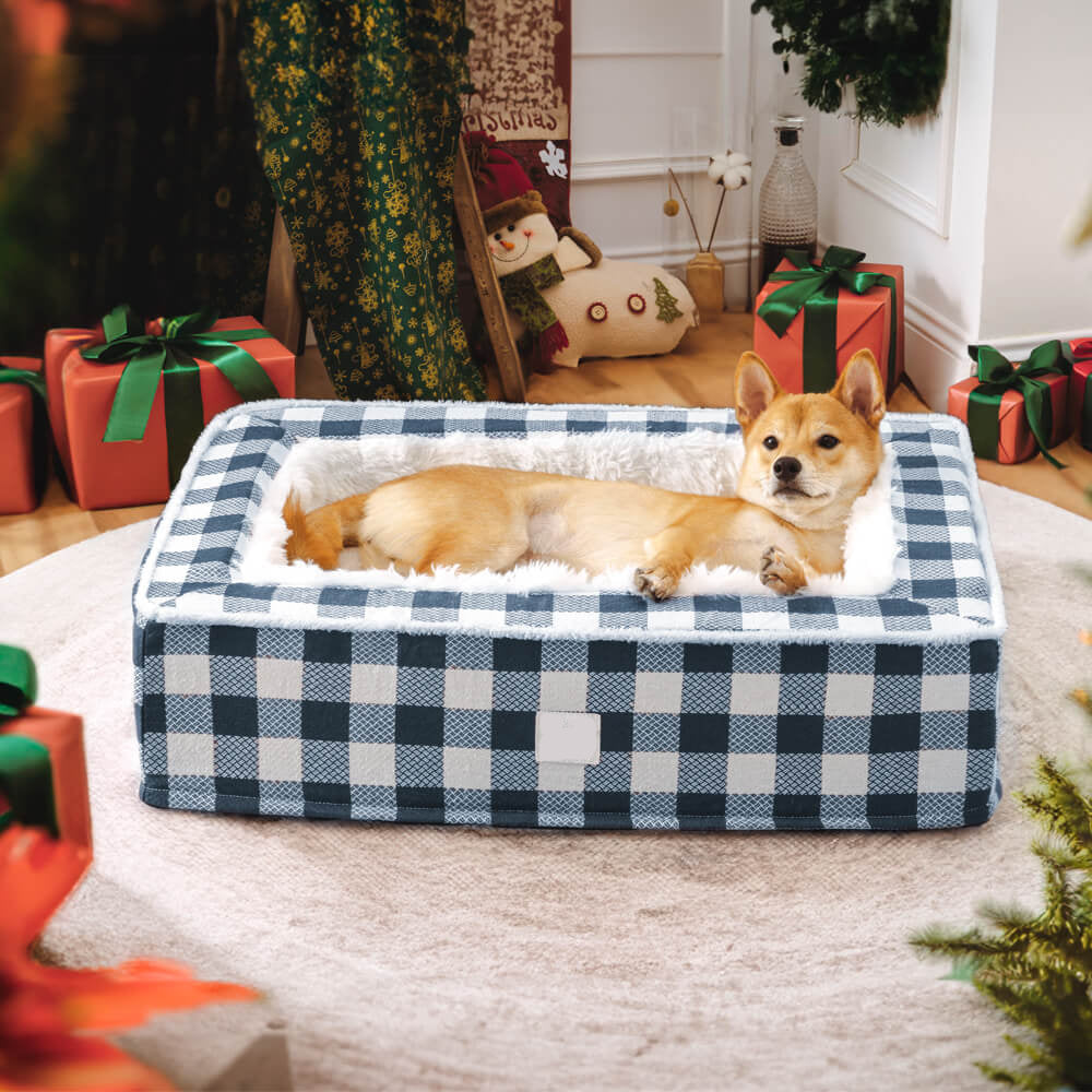 Dog lying on a checkered pet bed with Christmas decorations in the background