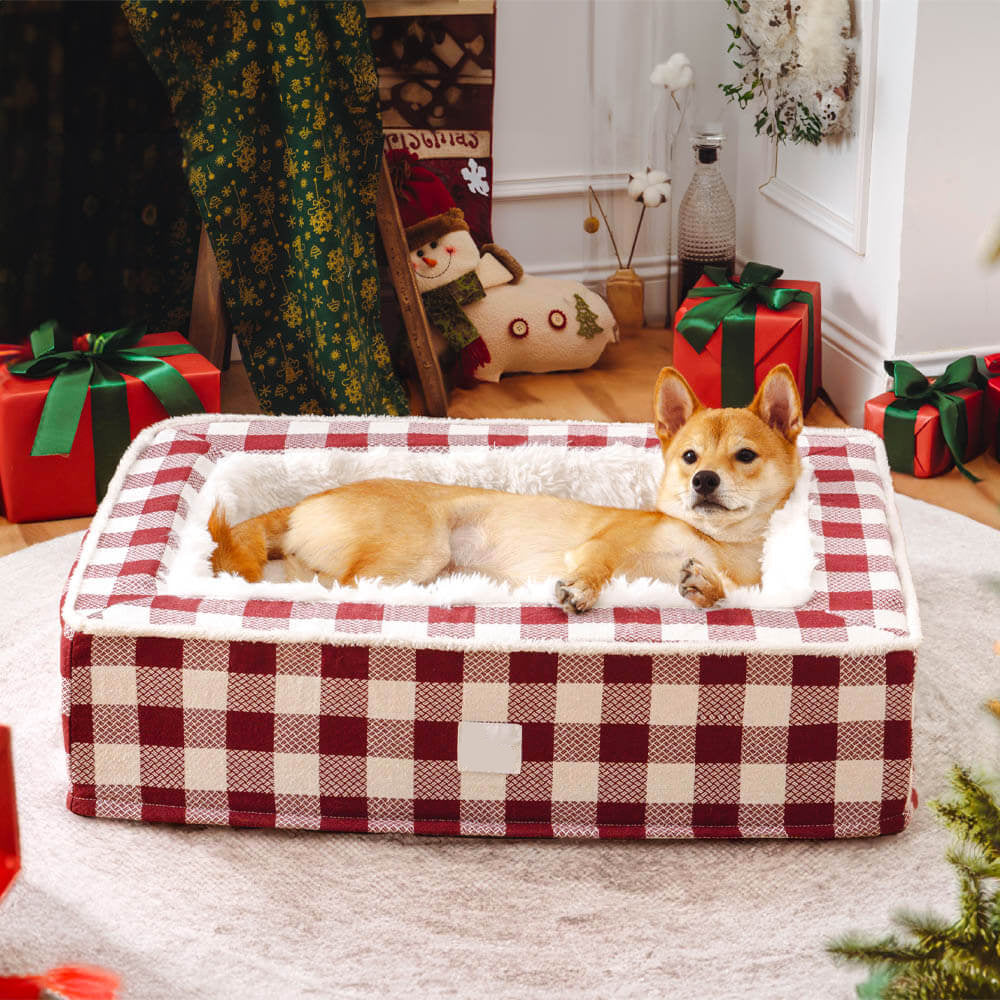 Dog lying on a red and white checkered pet bed with Christmas decorations in the background.